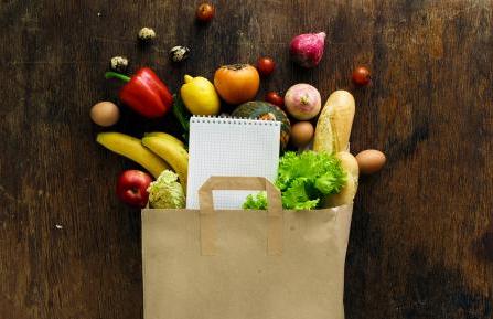 Healthy food spilling out of a paper grocery bag